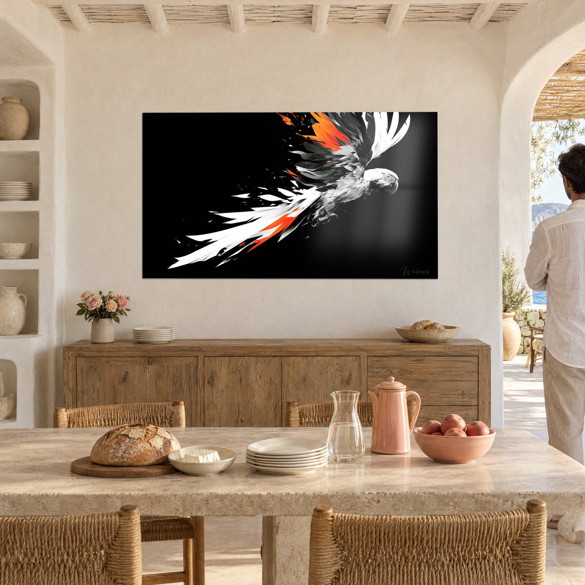 Wall art of a parrot in flight with tousled white, grey and orange feathers on a black background, on a dining room wall, a man walking past with his back turned