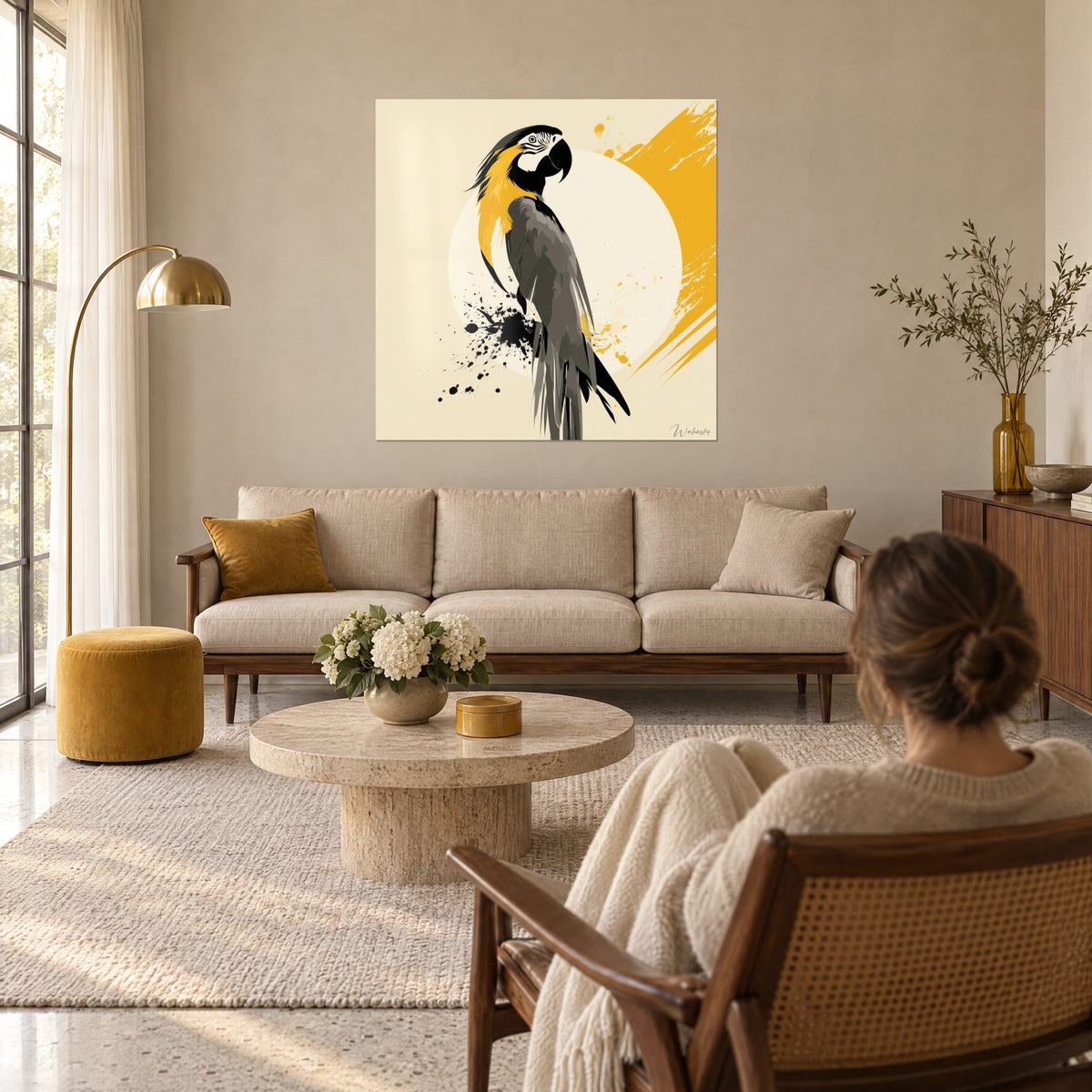 Tableau perroquet ara de profil, plumage gris anthracite et nuque dorée, éclaboussures d'encre noire, au-dessus d'un canapé dans un salon lumineux