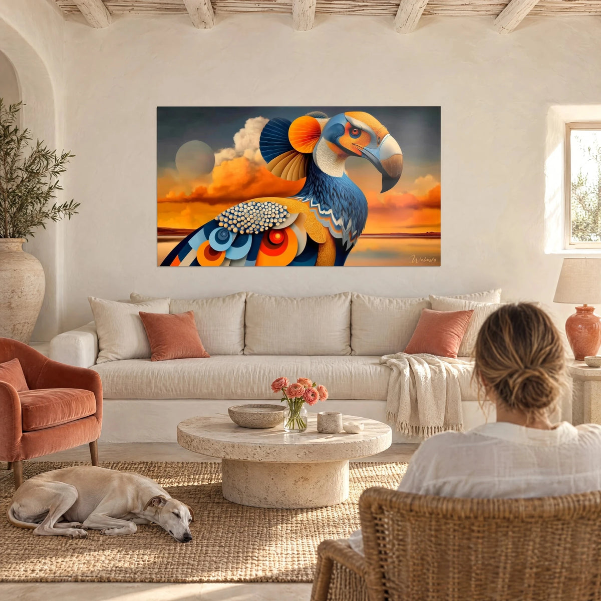 Quadro grande uccello stilizzato, piumaggio blu navy e ali arancioni su cielo ambrato, sopra un divano in un soggiorno luminoso