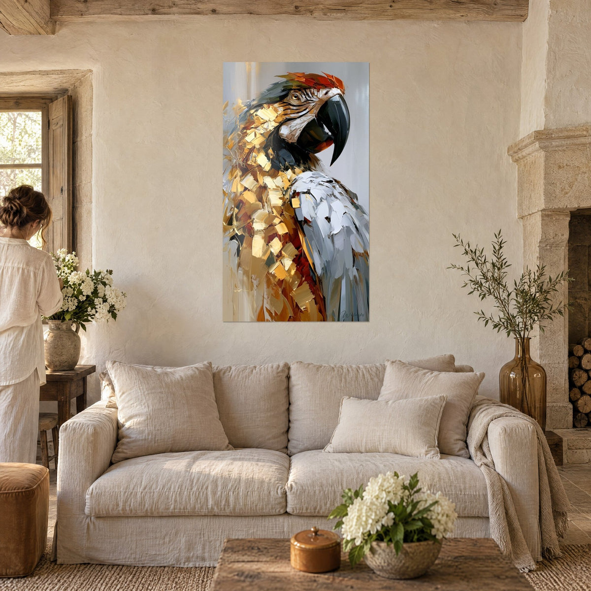 Gemälde Ara mit kupferfarbenen goldenen und perlgrauen Federn, schwarzer Schnabel leicht geöffnet, Frau von hinten, über einem Sofa in einem hellen Wohnzimmer