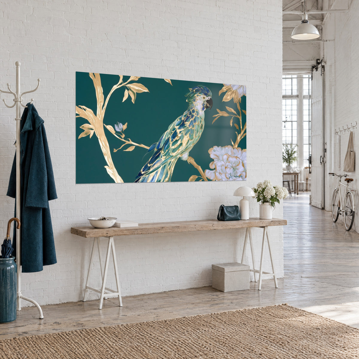 Tableau perroquet à huppe bleu cobalt, branches filigranées d'or et fleur ivoire sur vert profond, vu de trois-quarts dans un loft