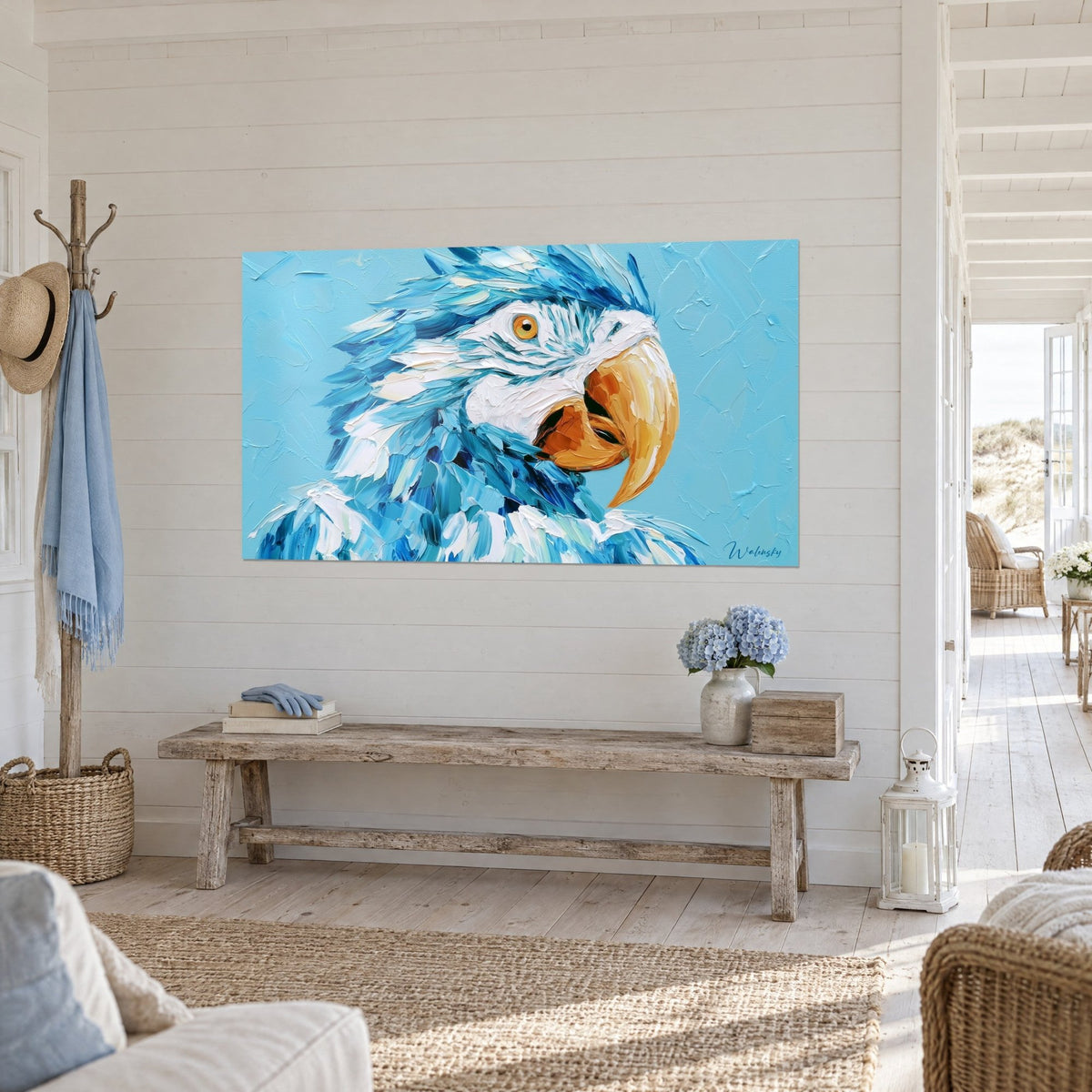 Wall art macaw with sky-blue and cream-white plumage, thick orange beak, seen three-quarter view above a light wood bench