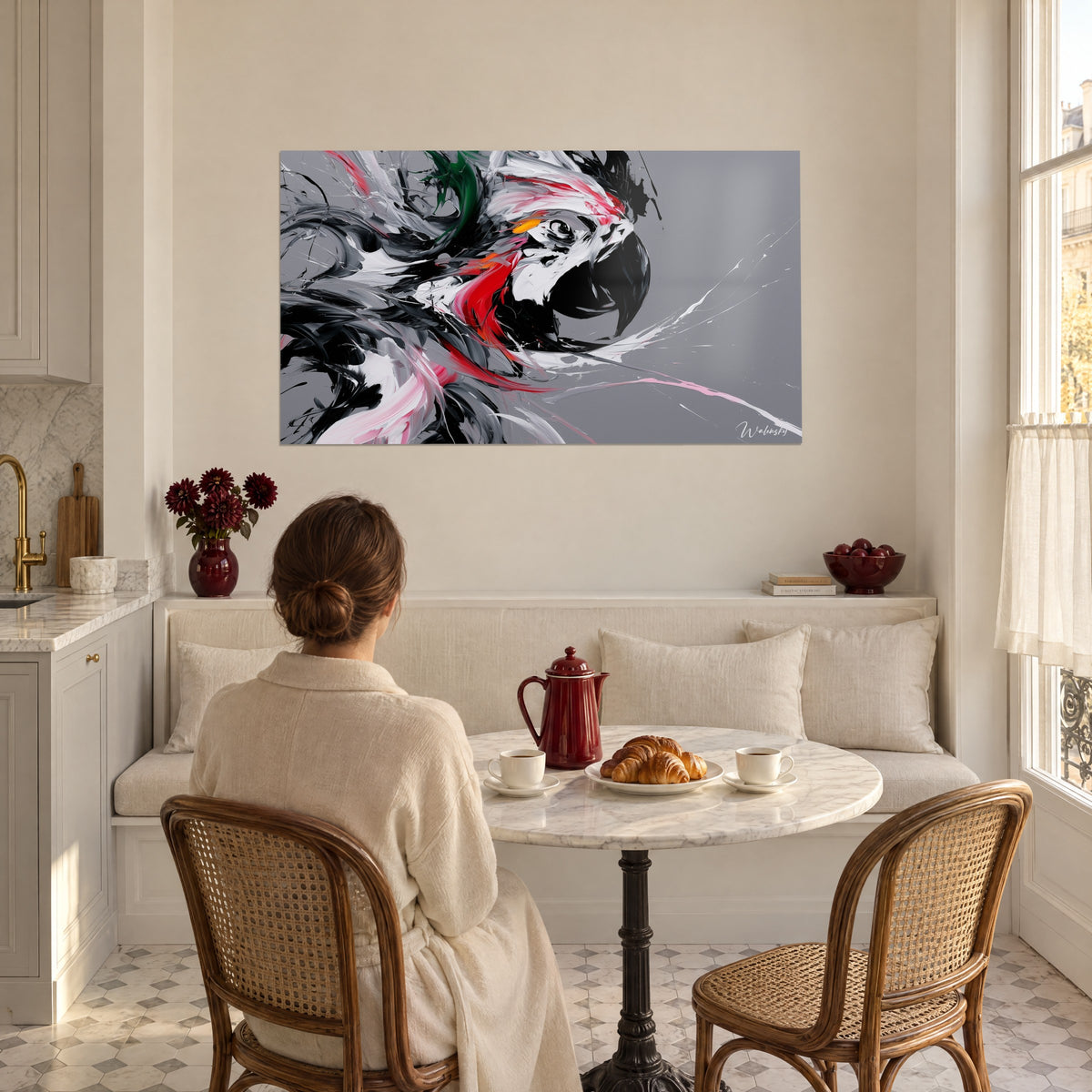 Tableau tête de perroquet aux plumes blanches, noires et carmin, admirée par une femme de dos dans une salle à manger