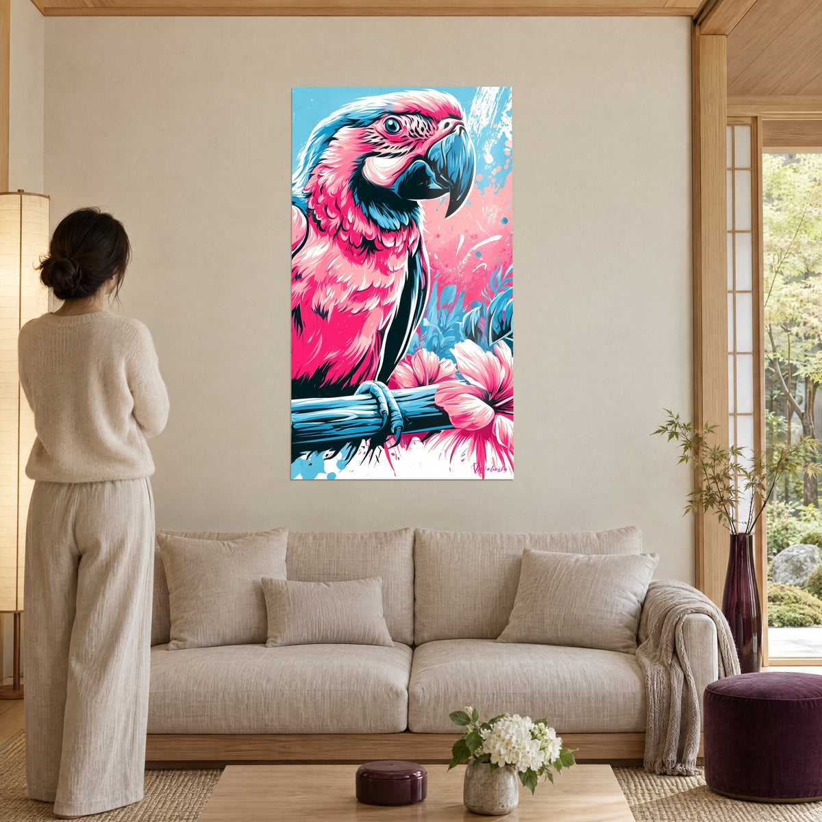 Tableau ara rose et bleu aux plumes en aplats vifs, bec ardoise et fleurs d'hibiscus, au-dessus d'un canapé dans un salon lumineux