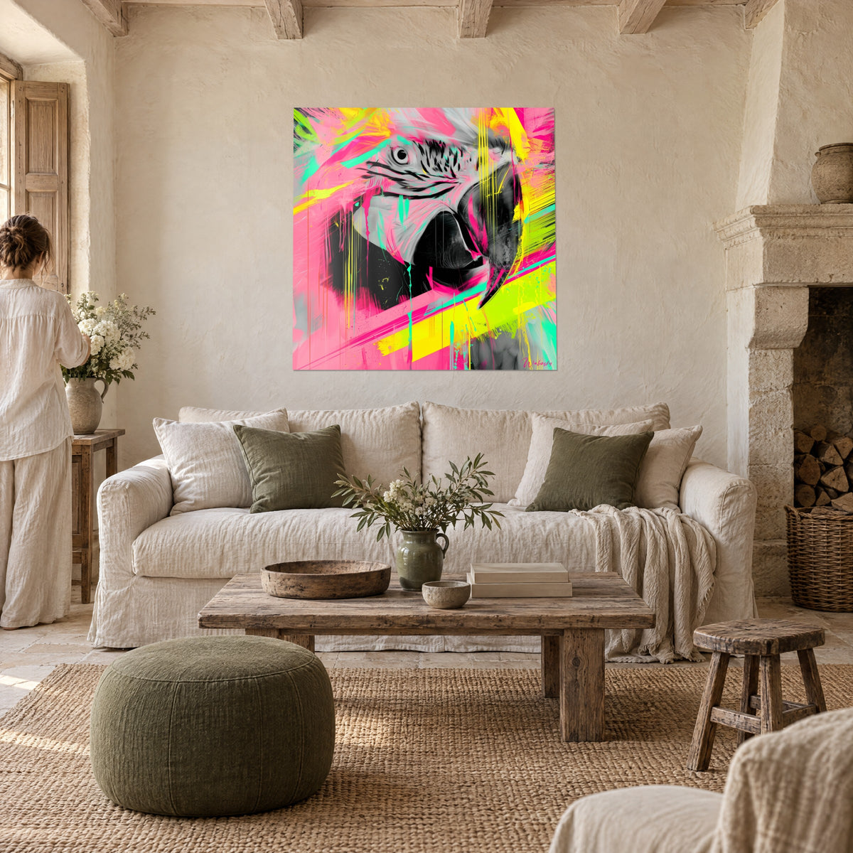 Tableau ara gris et blanc au regard cerclé, éclaboussures rose fluo et jaune citron, au-dessus d'un canapé dans un salon lumineux