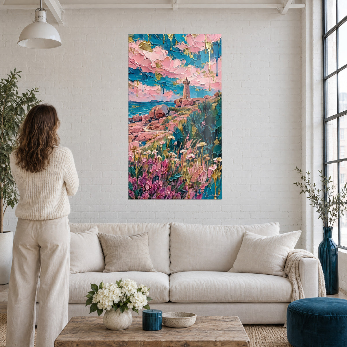 Wall art rose granite lighthouse on turquoise cliff, golden flowers, above a sofa in a bright living room