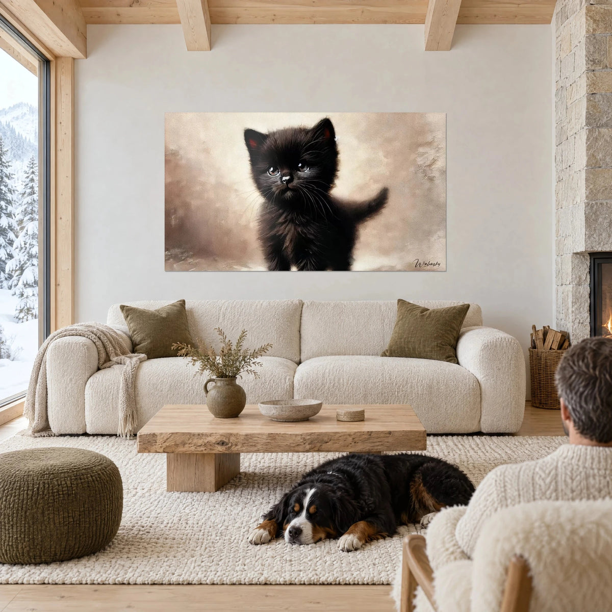 Quadro gattino nero dagli occhi grandi e luminosi, sfondo beige e crema, davanti a un cane sdraiato, sopra un divano in un soggiorno luminoso
