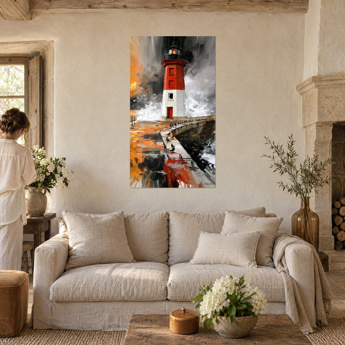 Wall art red and white lighthouse amid the spray, jetty dotted with black birds, a woman seen from behind, above a sofa in a bright living room