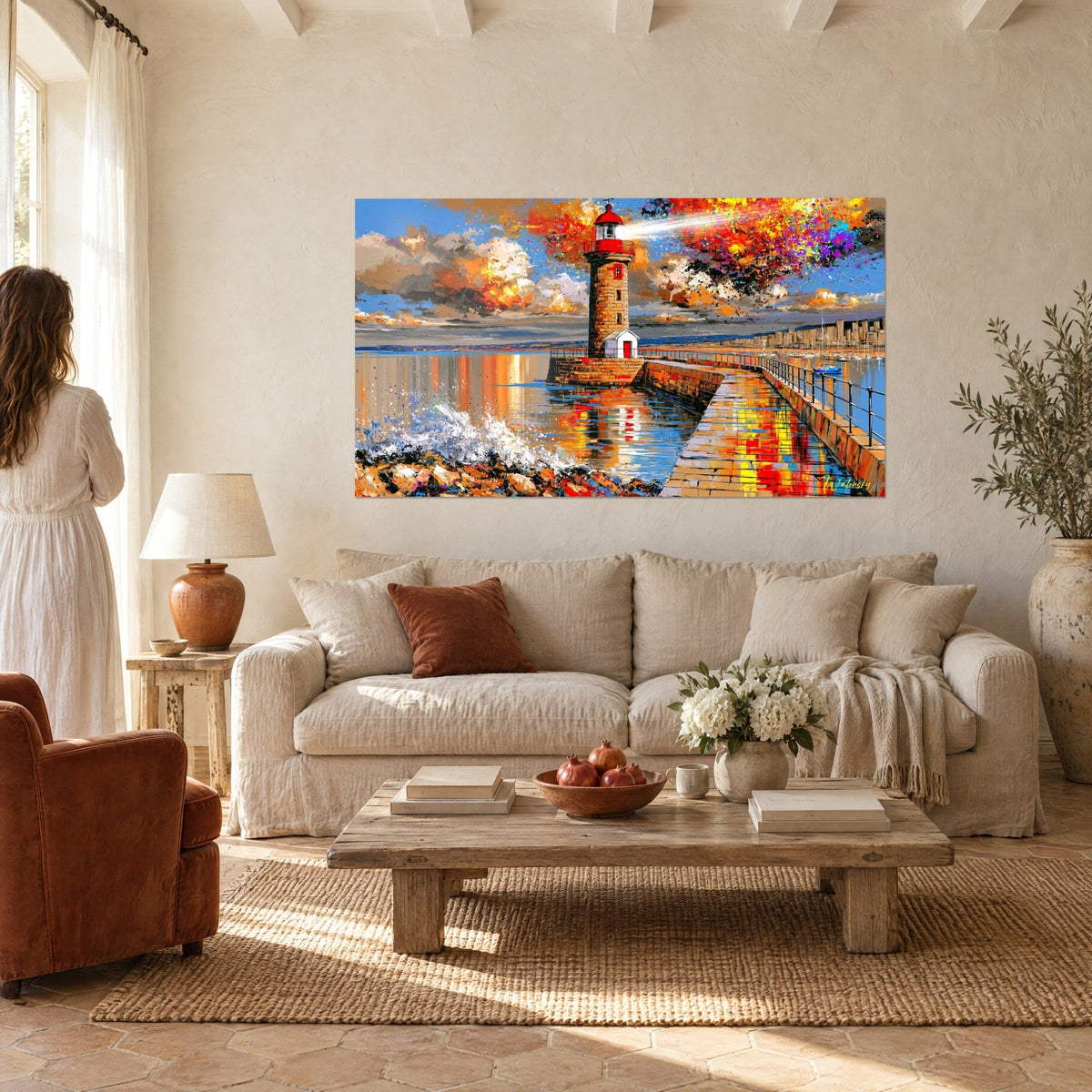 Tableau phare rouge et pierre dorée, éclaboussures orange sur ciel bleu, au-dessus d'un canapé dans un salon lumineux
