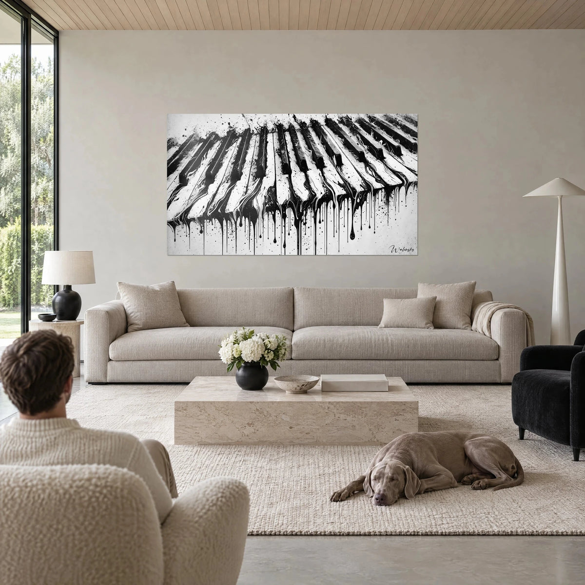 Schilderij zwart-witte pianotoetsen met inktdruipsporen, persoon van achteren, Weimaraner, boven een bank in een lichte woonkamer