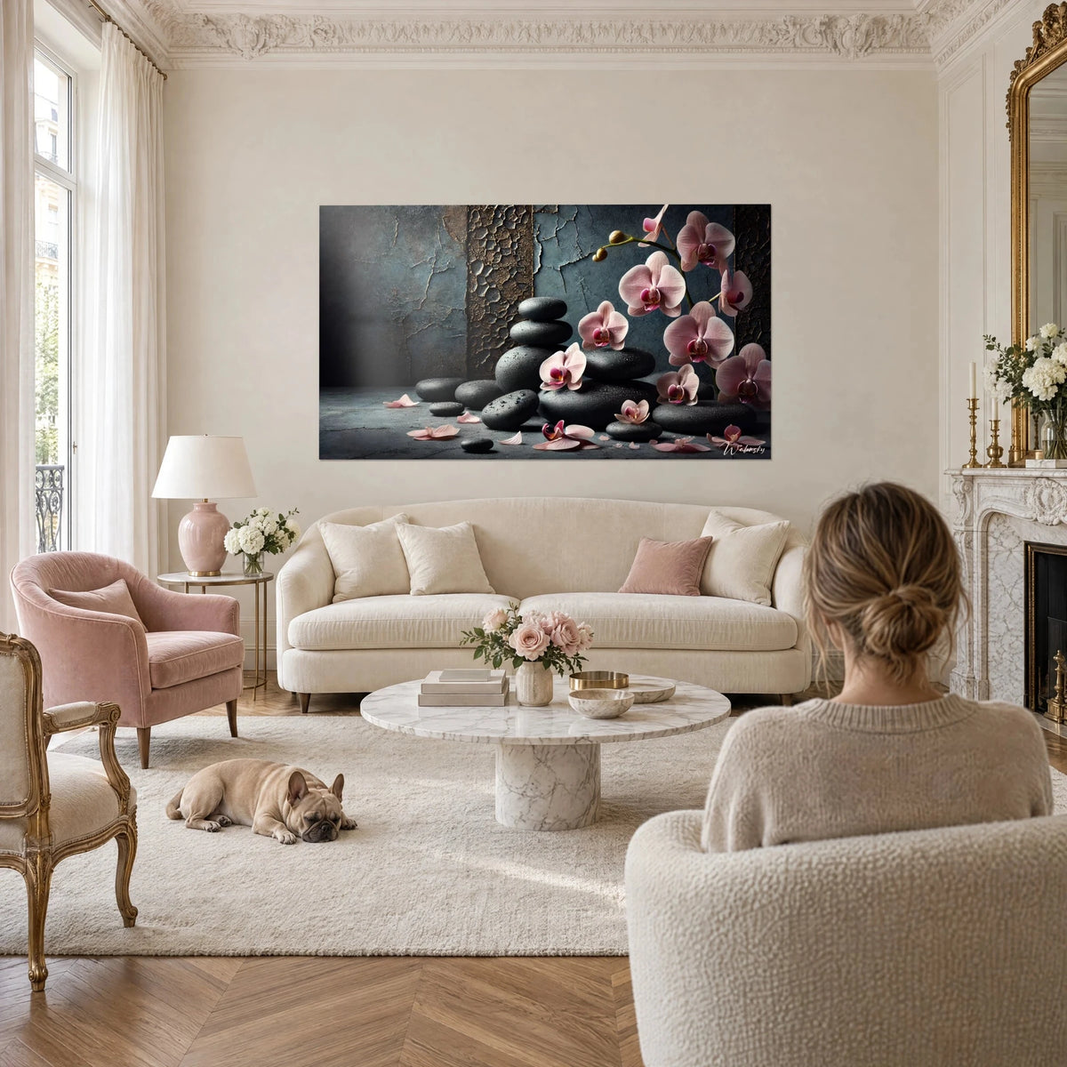 Quadro ciottoli neri perlati di rugiada e orchidee rosa su parete patinata grigio-azzurra, sopra un divano in un soggiorno luminoso