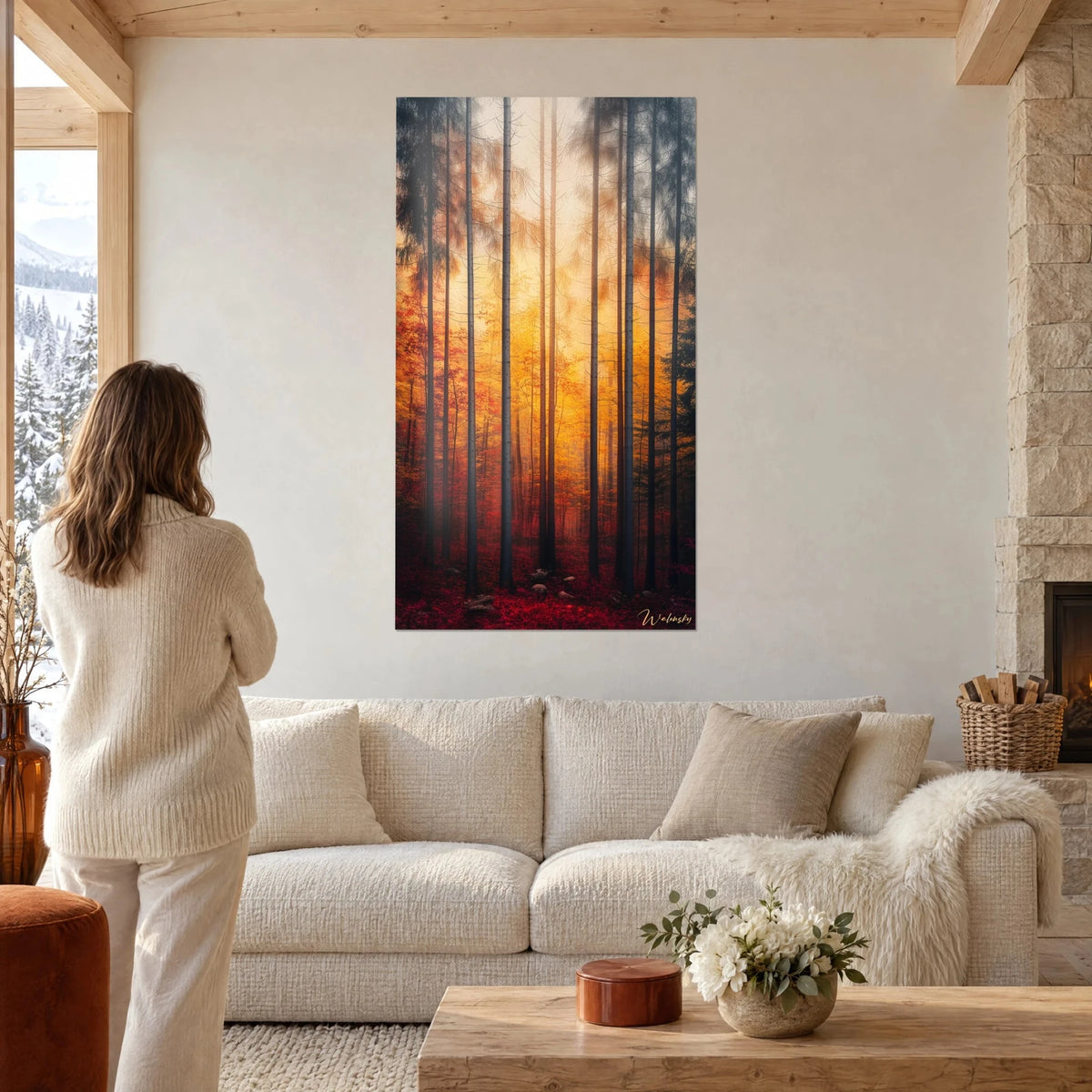 Quadro foresta di pini nella nebbia dorata, tronchi grigi slanciati e fogliame rosso, donna di spalle, sopra un divano in un soggiorno luminoso