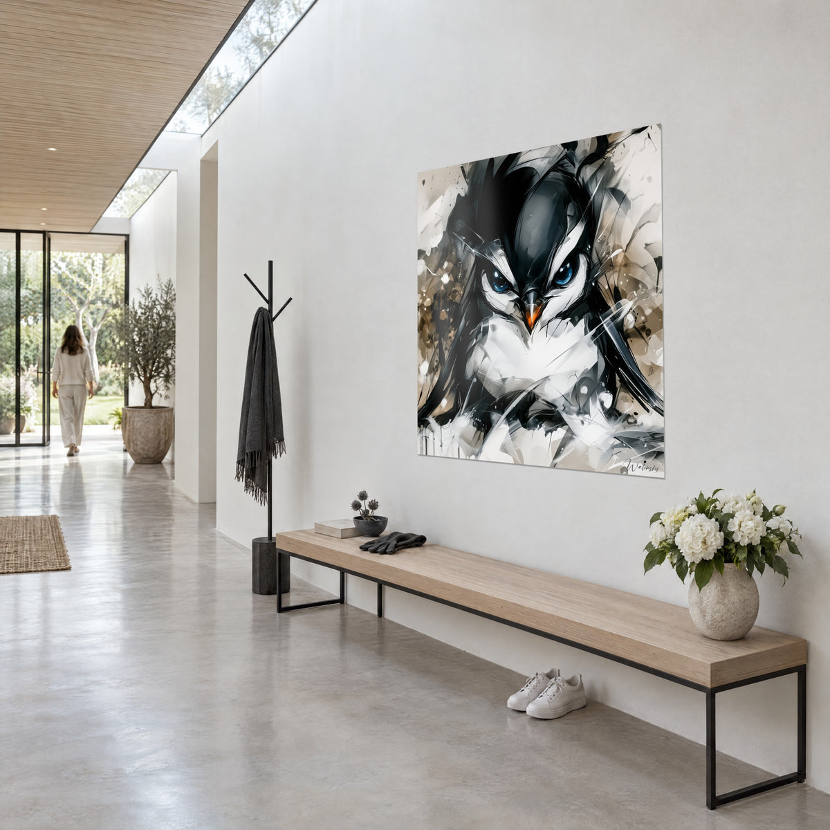Wall art black and white penguin with sapphire blue eyes, orange beak, sand-colored background, hung in a light hallway next to a wooden bench