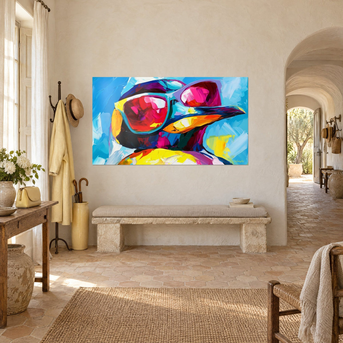 Tableau manchot chic, verres fuchsia et monture turquoise, ventre jaune citron, vu de trois quarts dans l'entrée d'un mas provençal