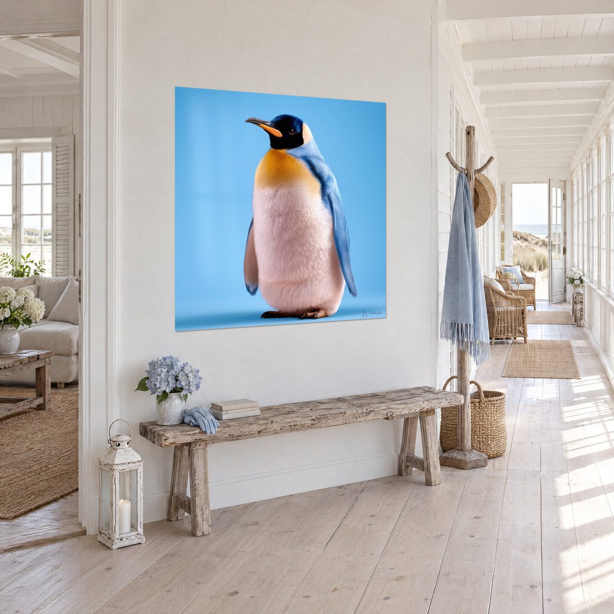 Tableau pingouin empereur de profil, bec orangé et tête noire sur fond azur, dans un couloir de maison en bord de mer
