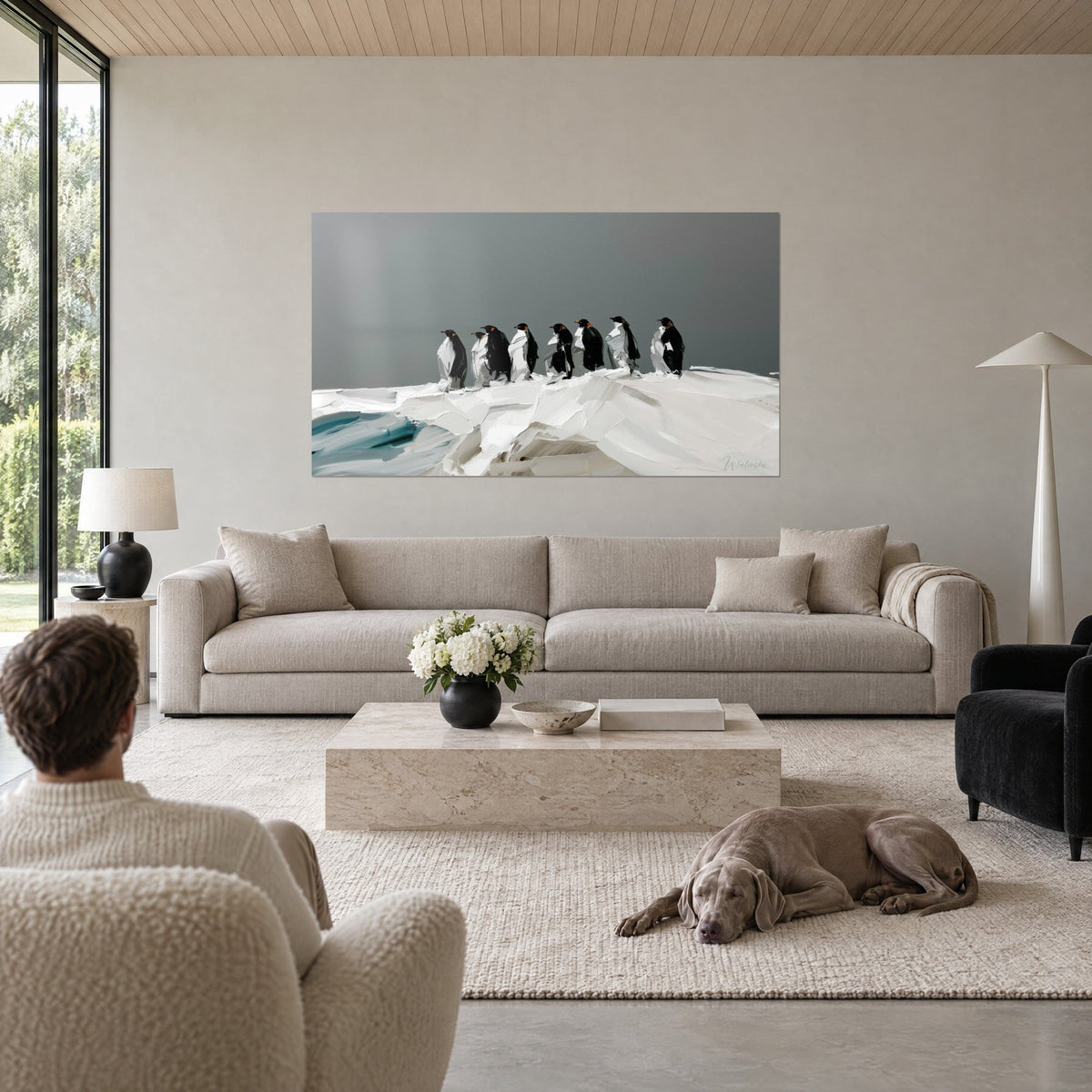 Gemälde schwarze Pinguine in Reihe auf weißer Eisscholle, schiefergrauer Himmel, dicke Spachtelstriche, über einem Sofa in einem hellen Wohnzimmer