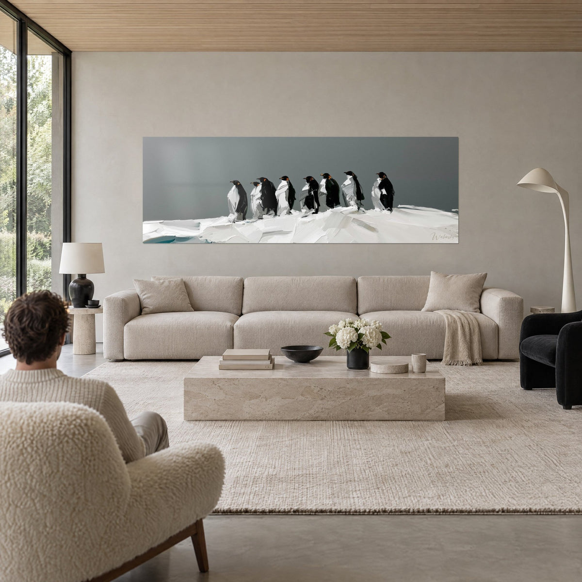 Gemälde Pinguine in einer Reihe auf dem Eis, schwarzes Gefieder und weiße Bäuche, grauer Himmel, über einem Sofa in einem hellen Wohnzimmer