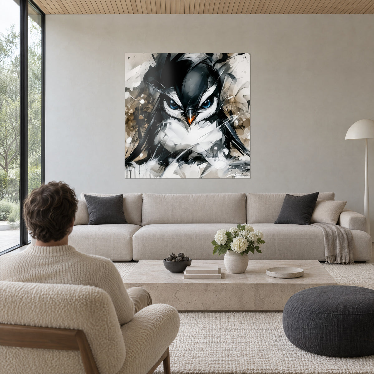 Wall art penguin with piercing blue gaze, black and white plumage, beige background, man seen from behind, above a sofa in a bright living room