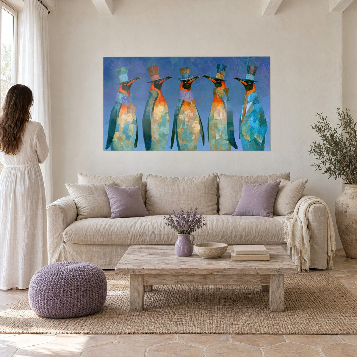 Gemälde fünf Pinguine mit Zylinder, blau-orangefarbenes Gefieder, von einer Frau von hinten betrachtet, über einem Sofa in einem hellen Wohnzimmer