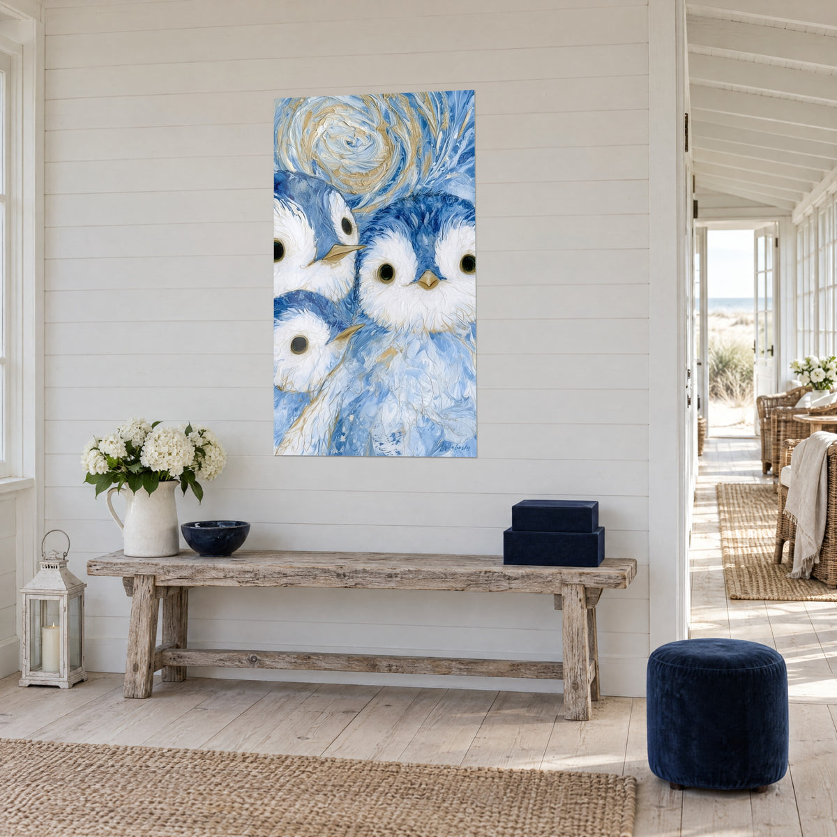 Wall art penguin chicks with round black eyes, ivory and blue plumage, ochre spiral, hung on a white plank wall, three-quarter view
