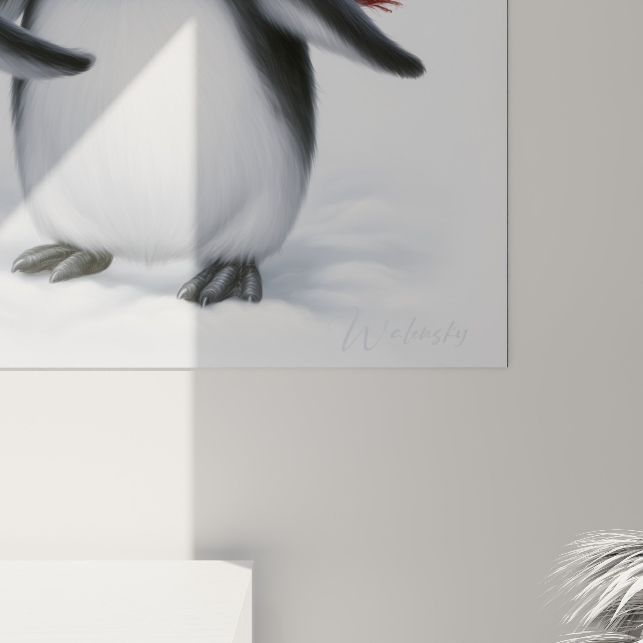 Détail du plumage texturé noir et blanc et de la laine tricotée rouge des bonnets sur cette œuvre encadrée
