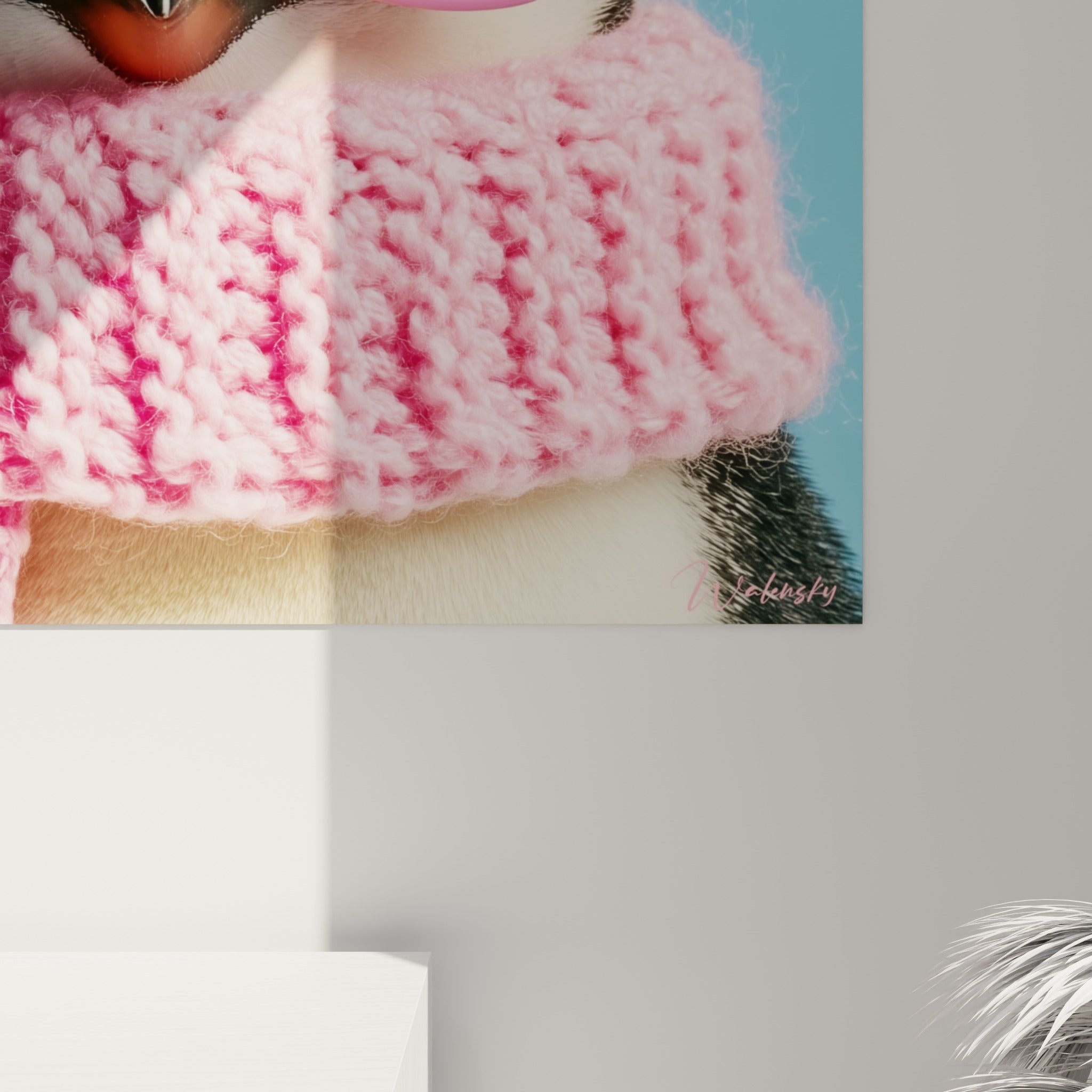 Tricot rose et vert du pingouin révèle son grain texturé et ses reliefs de laine en gros plan