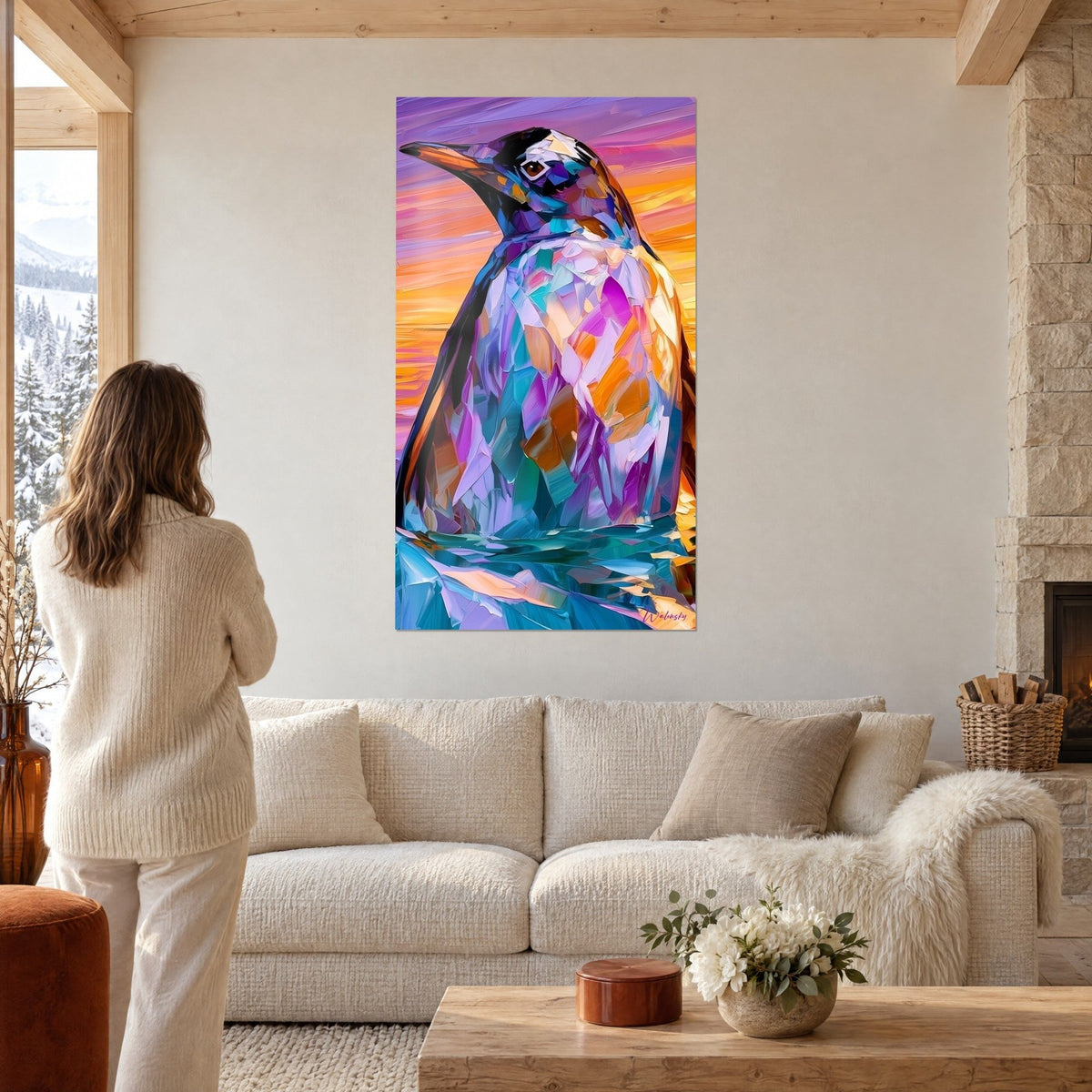 Tableau pingouin aux éclats violets et turquoise, ciel orangé, une femme de dos, au-dessus d'un canapé dans un salon lumineux