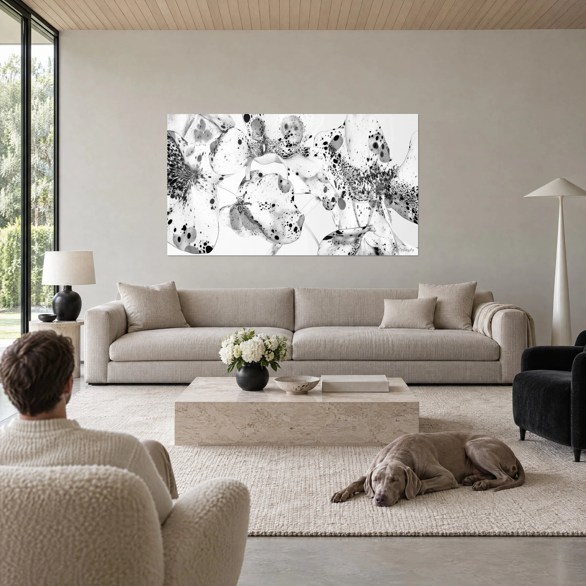 Quadro orchidee maculate in bianco e nero, petali macchiati d'inchiostro, sopra un divano in un soggiorno luminoso