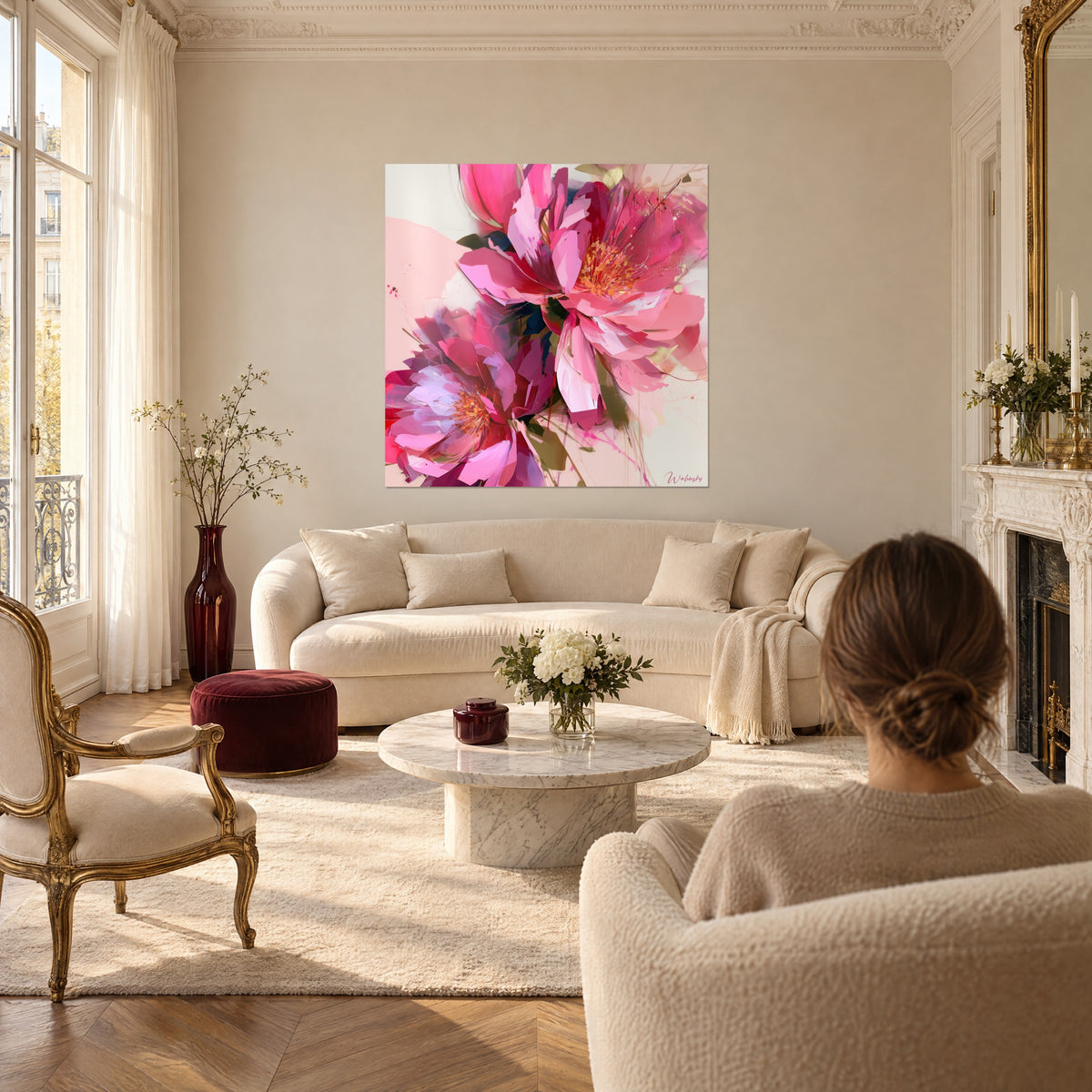 Schilderij roze pioenrozen met oranje meeldraden, fuchsia en parelmoerwitte bloemblaadjes, een vrouw met haar rug naar de kijker boven een bank in een lichte woonkamer