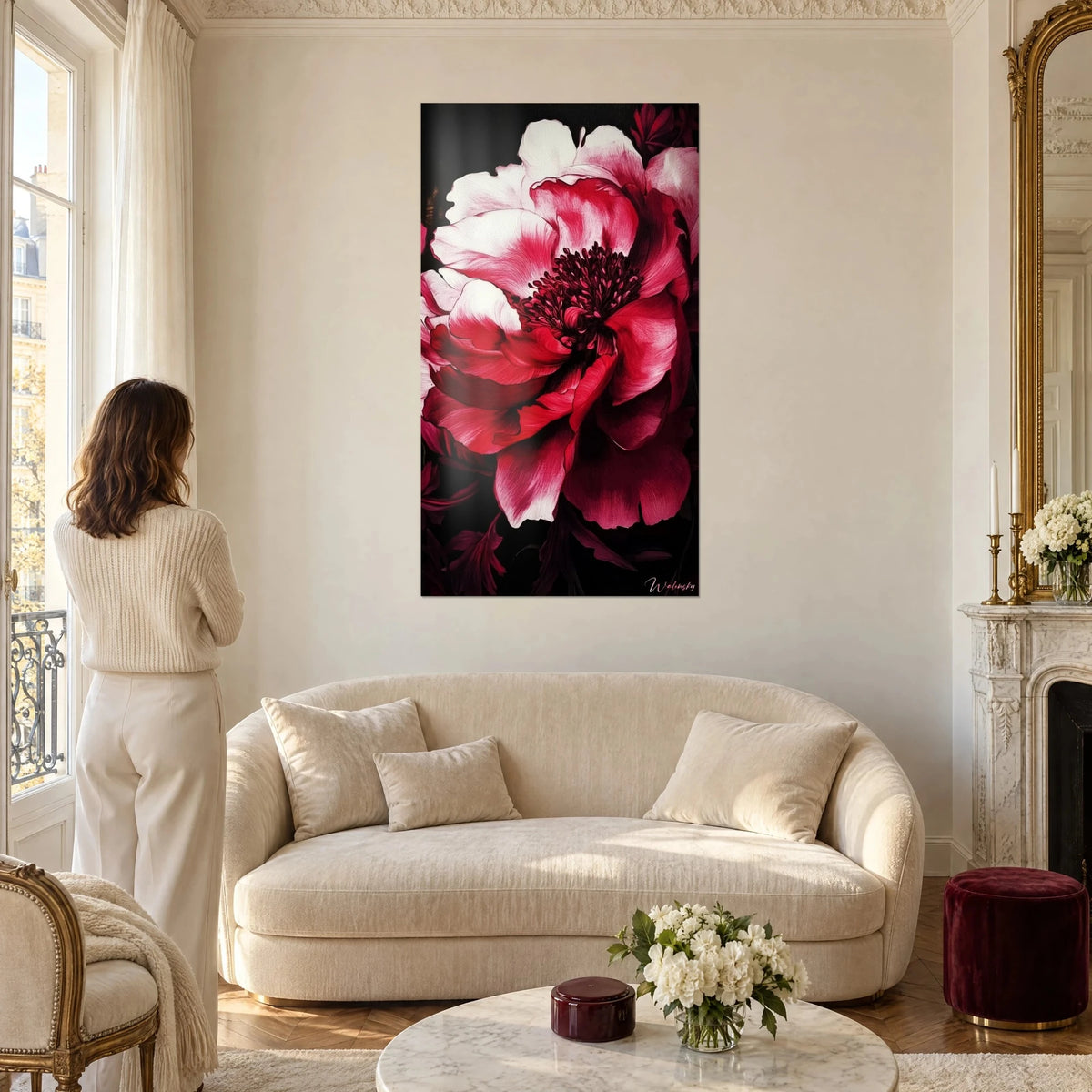 Wall art crimson peony with white petals and a purple stamen centre, woman seen from behind, above a sofa in a bright living room