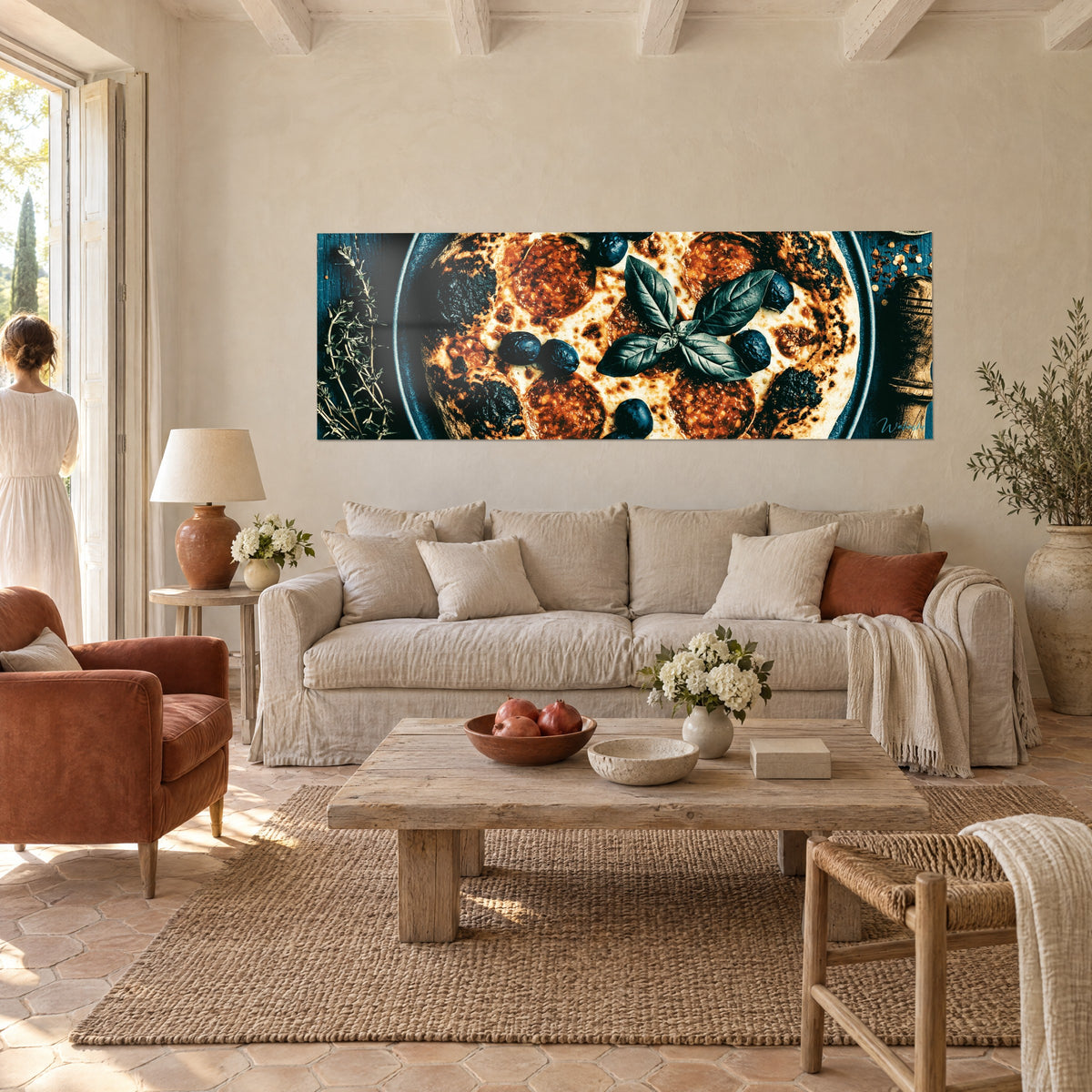 Tableau pizza au pepperoni grillé, croûte noircie et basilic vert sombre, bleu pétrole, une femme de dos, au-dessus d'un canapé dans un salon lumineux