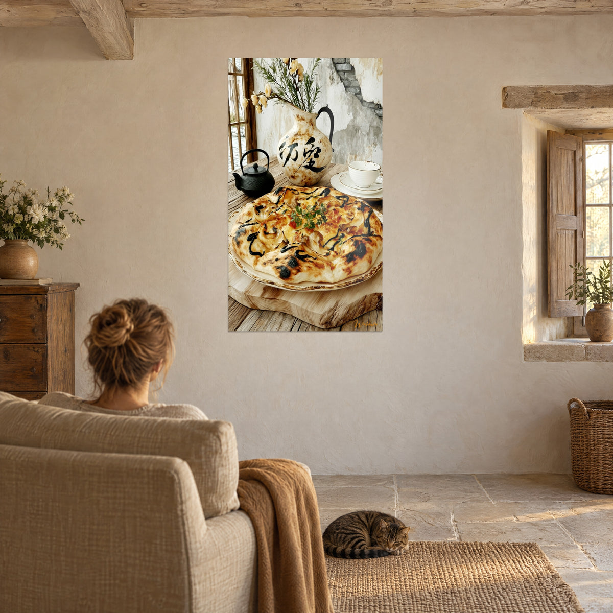 Tableau pizza dorée parsemée de persil vert, cruche crème aux idéogrammes noirs, femme de dos dans un fauteuil, chat tigré couché