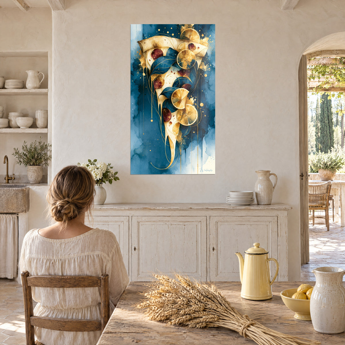 Tableau pizza fondante aux citrons ambrés et rondelles bordeaux sur fond turquoise, une femme de dos dans une cuisine de mas