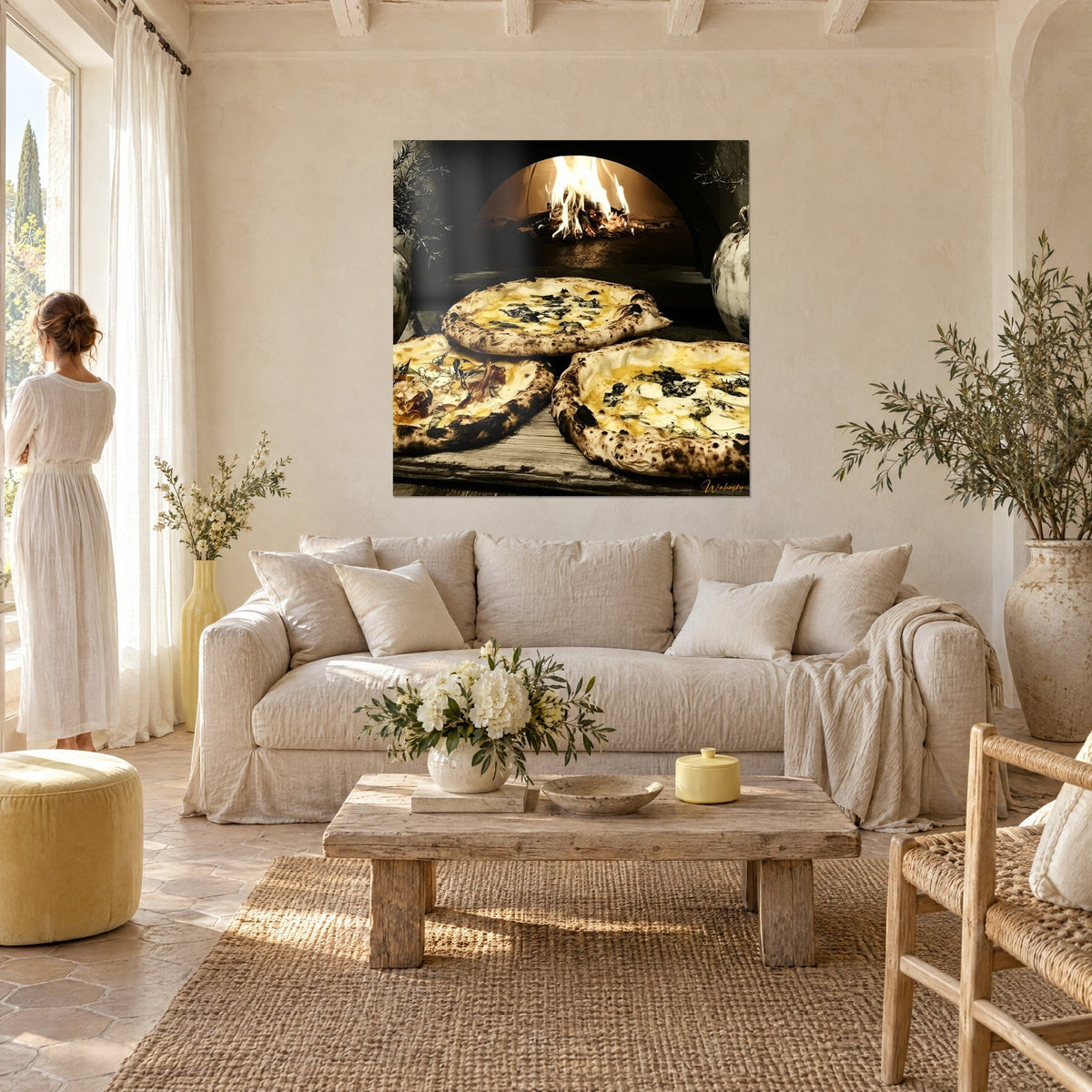 Tableau trois pizzas blanches à la croûte noircie devant un four à bois flamboyant, ocre et crème, au-dessus d'un canapé dans un salon lumineux