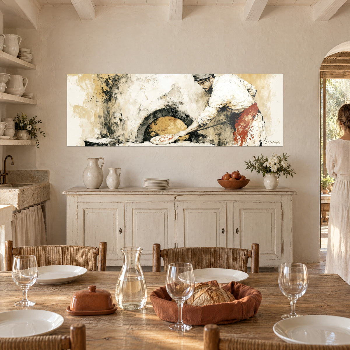 Tableau cuisinier de pizza napolitaine et sa pelle en bois, tablier rouge, fond ocre et ivoire, accroché au-dessus d'un buffet blanc avec couple de dos