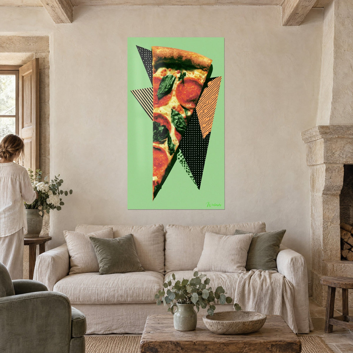 Wall art pizza slice with pepperoni and spinach on black and orange polka-dot triangles, almond green background, above a sofa in a bright living room