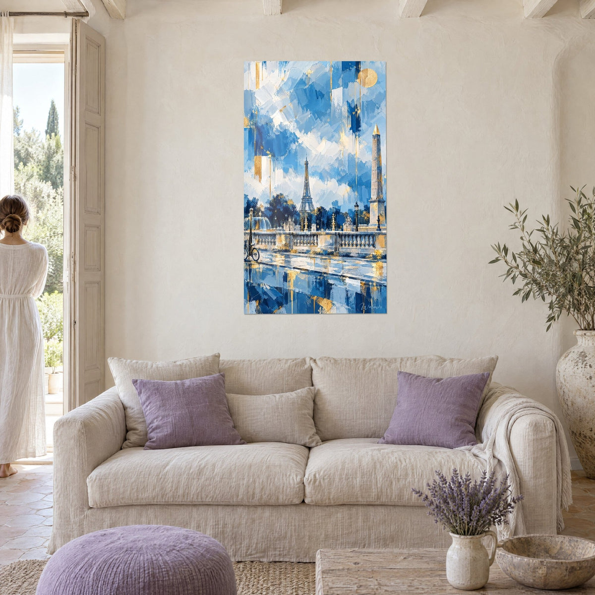 Wall art: Golden obelisk dominating the Place de la Concorde in bold blue palette-knife strokes, seen by a woman from behind above a sofa in a bright living room