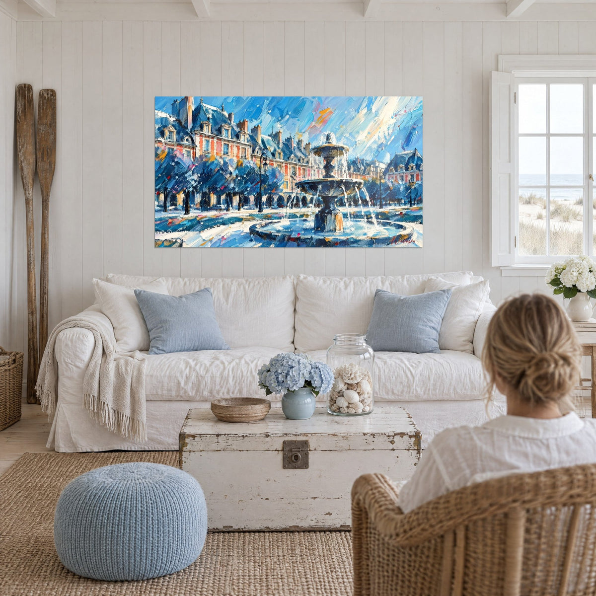 Gemälde Springbrunnen mit eisblauen und orangefarbenen Wasserstrahlen, rosa Ziegelfassaden, über einem Sofa in einem hellen Wohnzimmer
