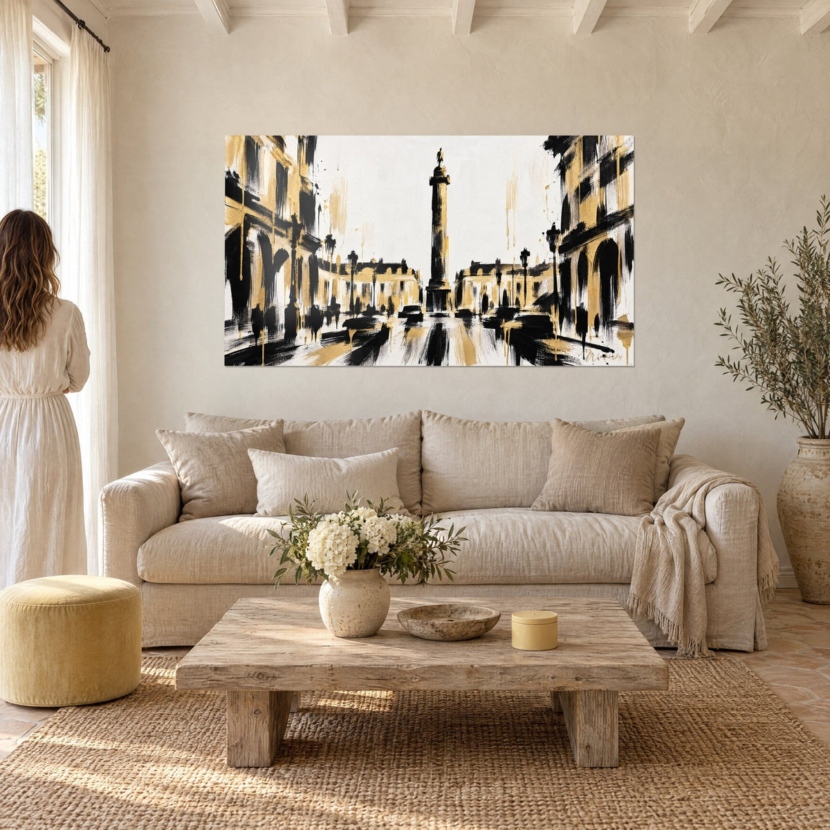 Tableau colonne napoléonienne noire et dorée, traits de pinceau et coulures d'or sur fond blanc, au-dessus d'un canapé dans un salon lumineux