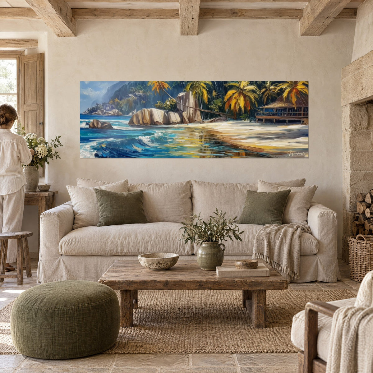 Wall art tropical beach with beige granite rocks and ochre palm trees, turquoise sea, a woman seen from behind above a sofa in a bright living room