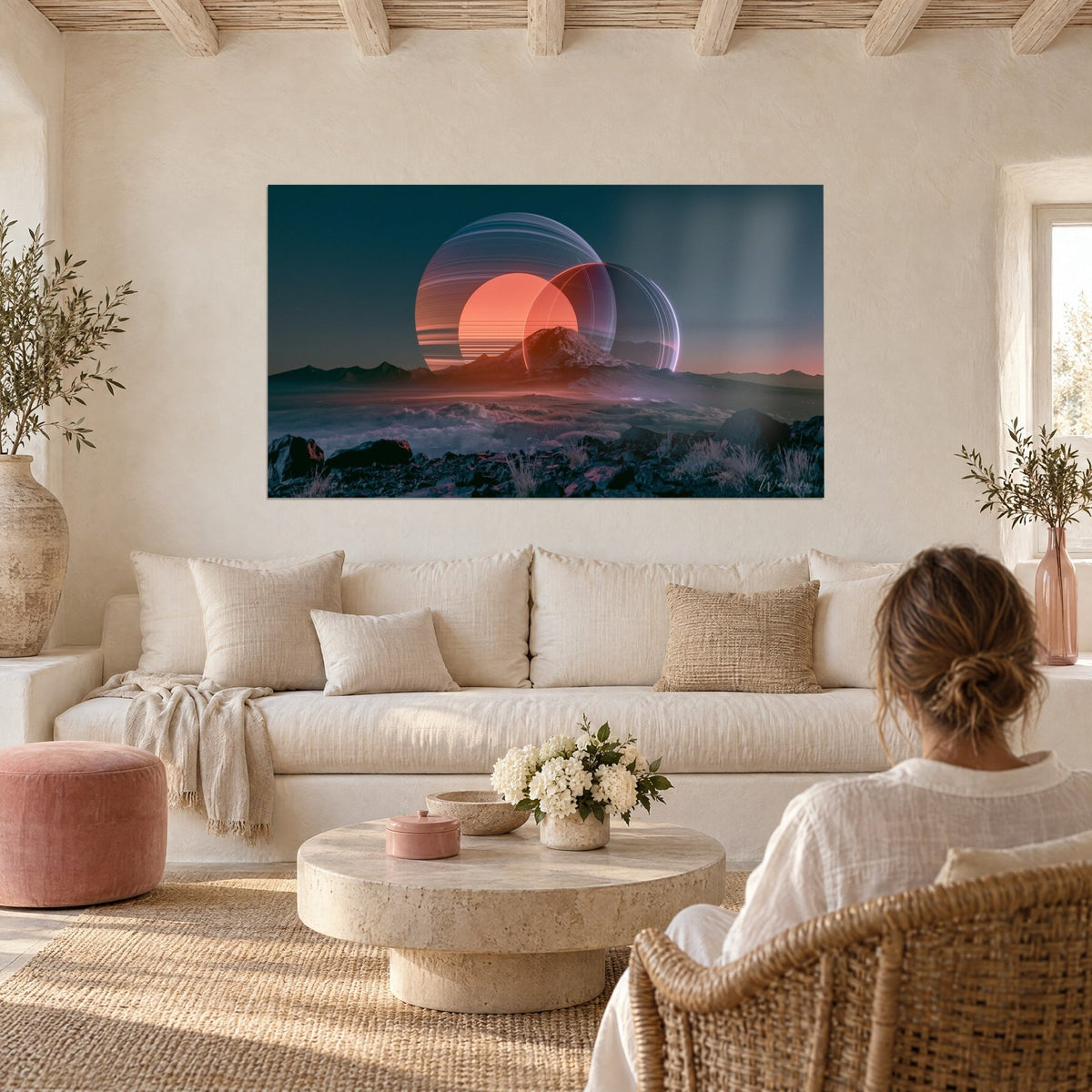 Tableau disque solaire saumon derrière un anneau translucide, pic rocheux bleu nuit, femme de dos, au-dessus d'un canapé dans un salon lumineux