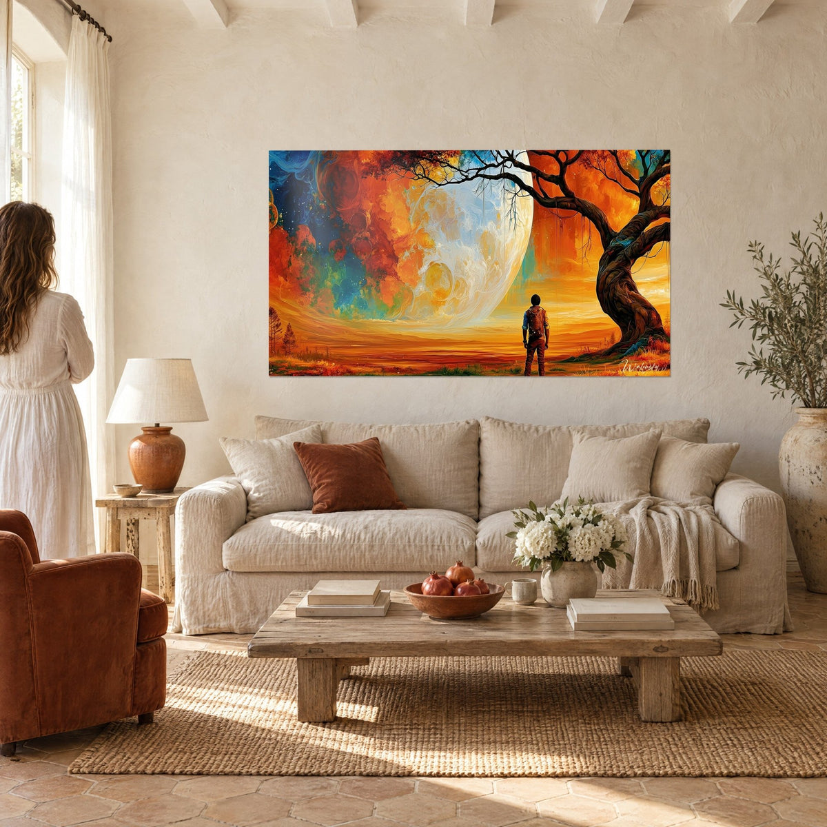 Wall art hiker with backpack facing a giant orange and cream moon, dark tree, above a sofa in a bright living room