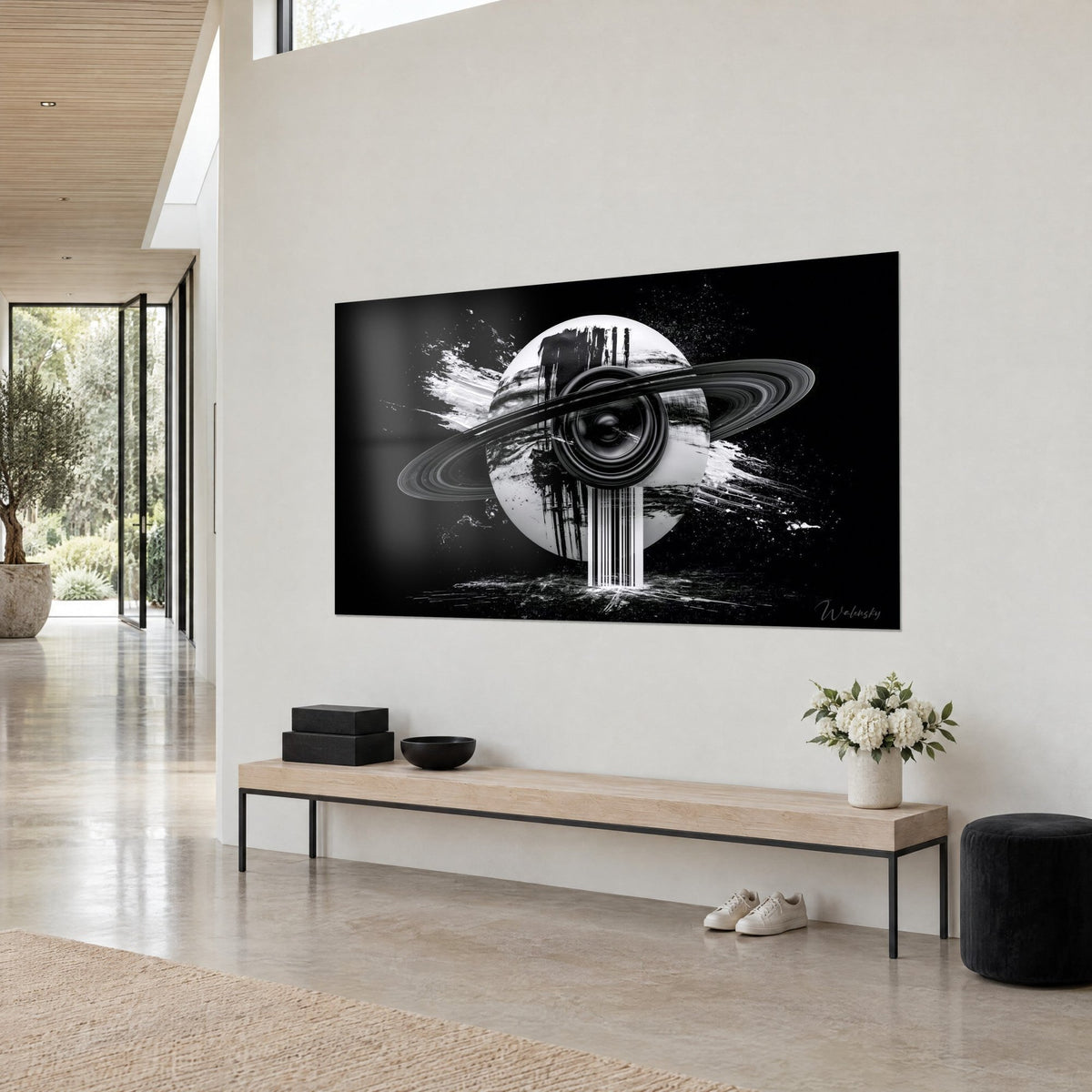 Tableau globe lunaire strié de coulures noires, anneau gris chromé et membrane de haut-parleur, mur blanc, banc en bois clair