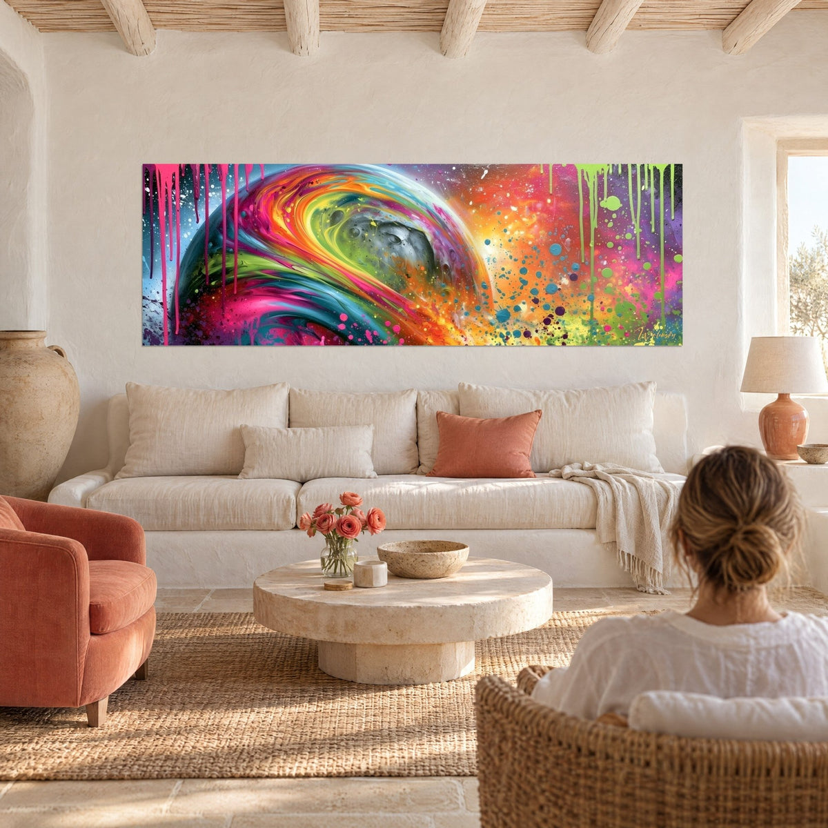 Gemälde Mondglobus in Grau mit fuchsiafarbenen und orangefarbenen Spiralen, rosa Schlieren, Frau von hinten über einem Sofa in einem hellen Wohnzimmer