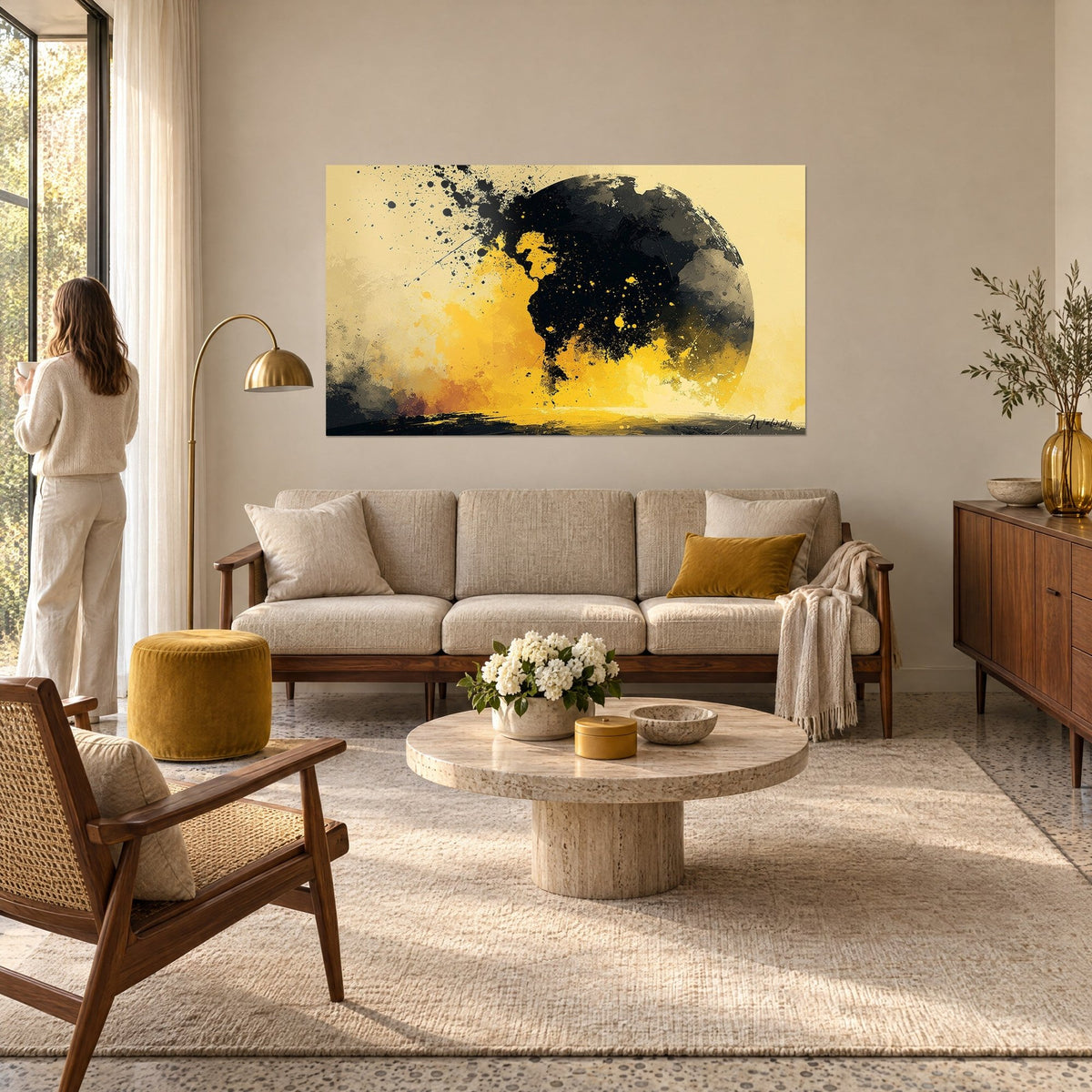 Tableau globe d'encre noire éclaboussé sur fond jaune soleil, taches projetées, au-dessus d'un canapé dans un salon lumineux