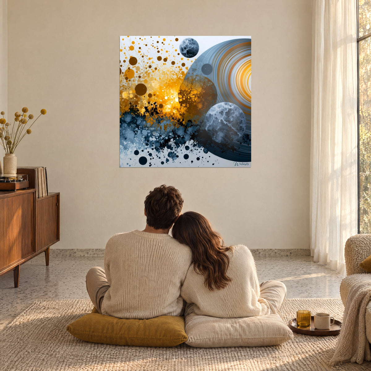 Tableau galaxie de cercles ambrés et ardoise aux veinures blanches, couple de dos sur coussins, grande baie vitrée