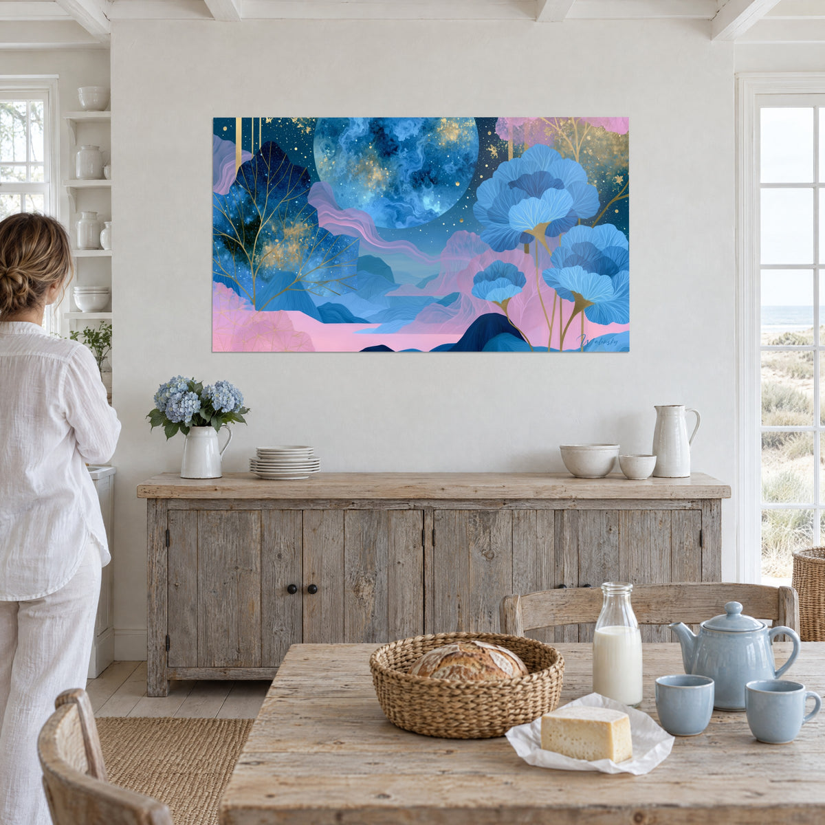 Tableau globe céleste bleu marine et or, arbres aux branches dorées, nappes roses ondulées, mur blanc d'une salle à manger bord de mer