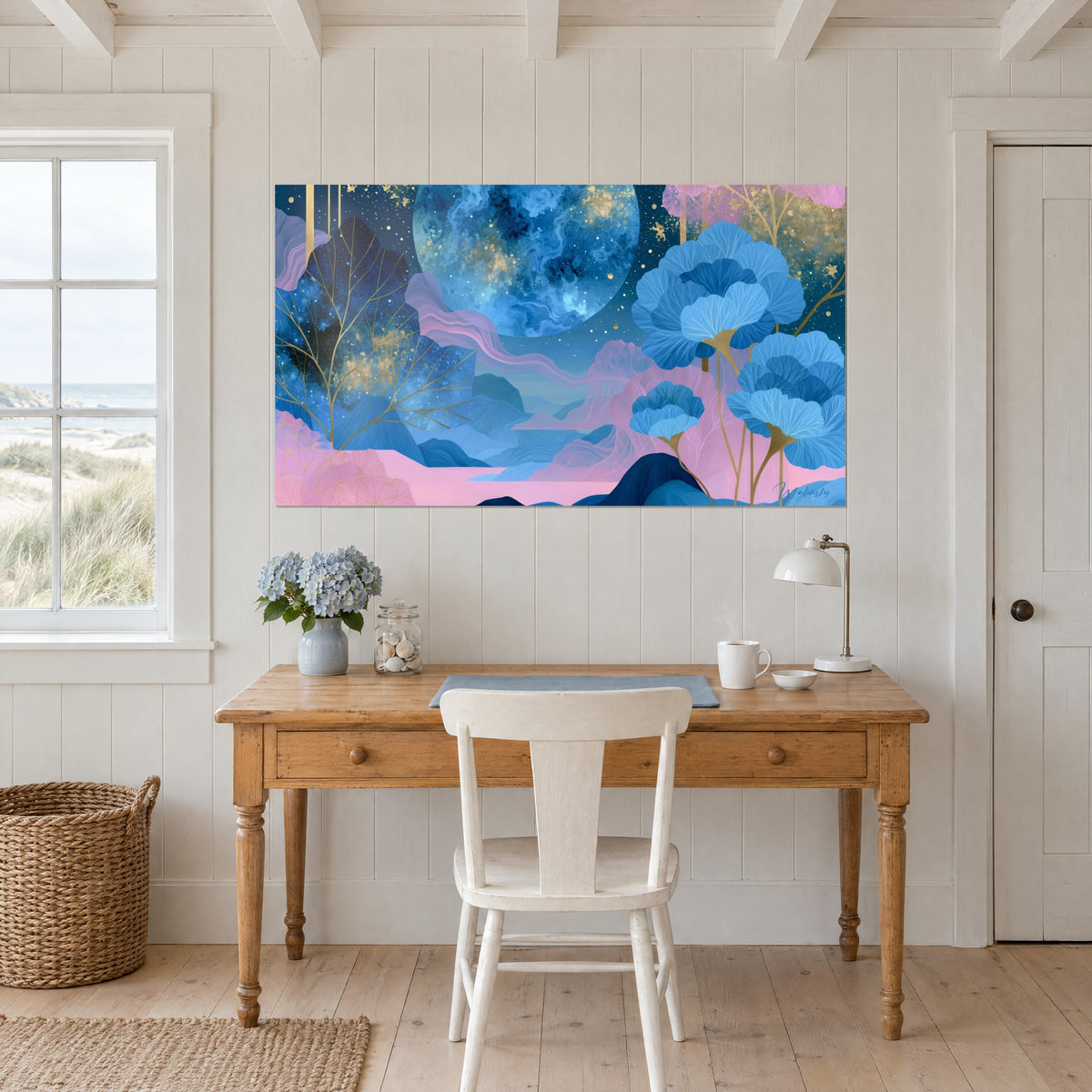 Tableau paysage cosmique aux collines bleues et roses, corolles de ginkgo azur et brindilles dorées, au-dessus d'un bureau en bois clair