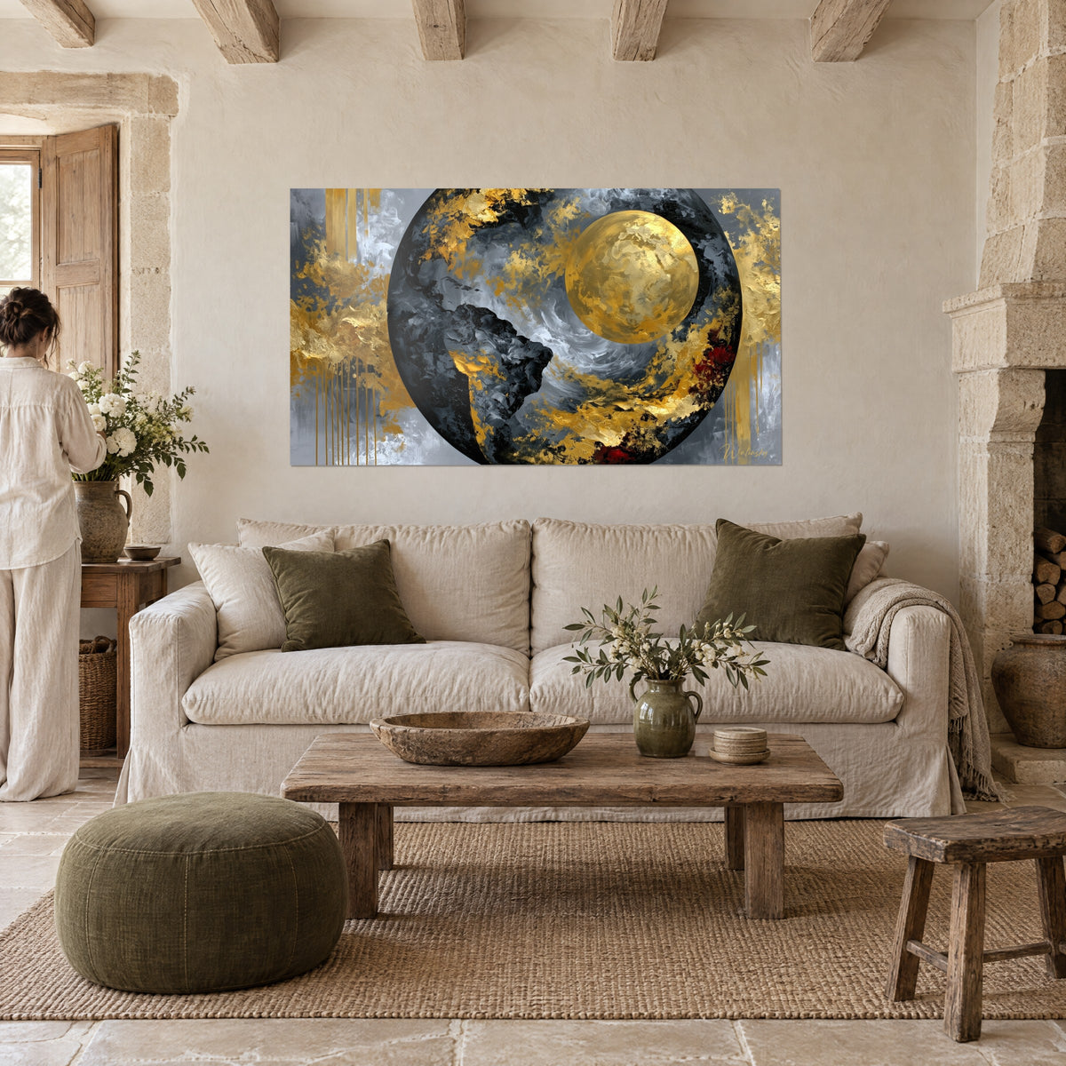 Tableau globe noir strié de gris et d'or, lune dorée massive en relief, personne de dos, au-dessus d'un canapé dans un salon lumineux