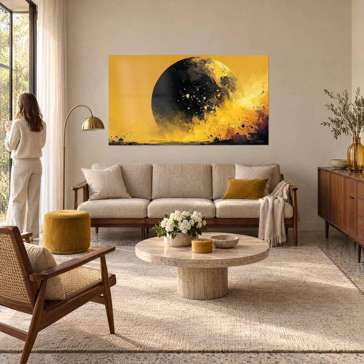 Wall art ebony globe speckled with gold, mustard-yellow cloud at bottom right, above a sofa in a bright living room